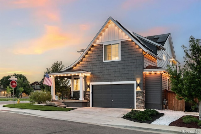 11187 W 53rd Dr, Wheat Ridge, CO 80033 - view of front of property featuring an attached garage, roof mounted solar panels, driveway, and board and batten siding