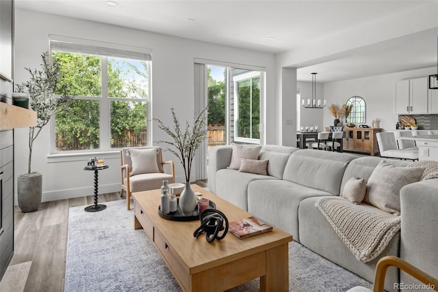 11187 W 53rd Dr, Wheat Ridge, CO 80033 - living area featuring healthy amount of natural light, a chandelier, wood finished floors, and recessed lighting