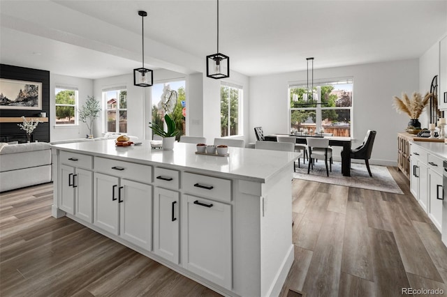 11187 W 53rd Dr, Wheat Ridge, CO 80033 - kitchen with light wood-style flooring, white cabinetry, light countertops, open floor plan, and healthy amount of natural light