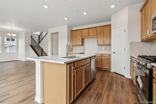 kitchen featuring hardwood / wood-style flooring, stainless steel appliances, a kitchen island with sink, and sink