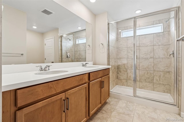 bathroom featuring vanity, a wealth of natural light, and a shower with shower door