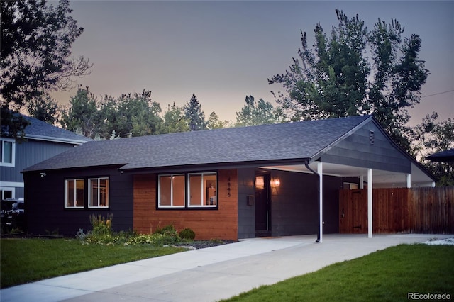 single story home featuring a lawn and a carport