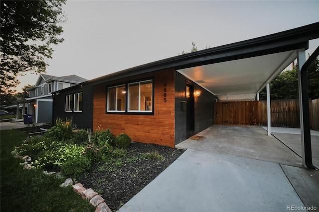 property exterior at dusk featuring a carport