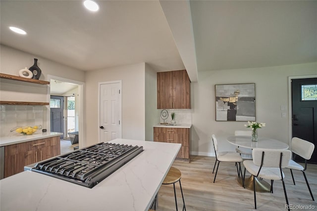 kitchen with light hardwood / wood-style flooring, backsplash, and a breakfast bar