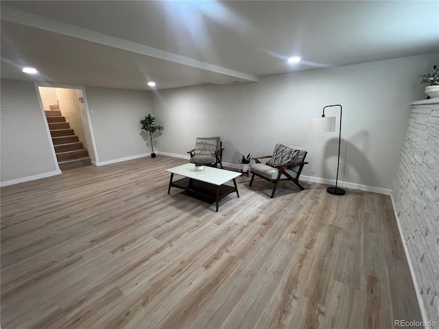 sitting room featuring light hardwood / wood-style floors and a stone fireplace