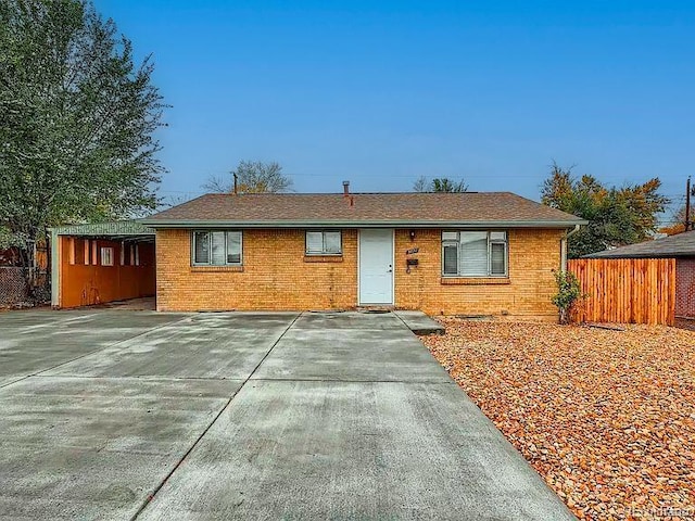 ranch-style home featuring fence and brick siding