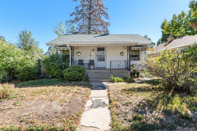 bungalow-style home with covered porch and a chimney