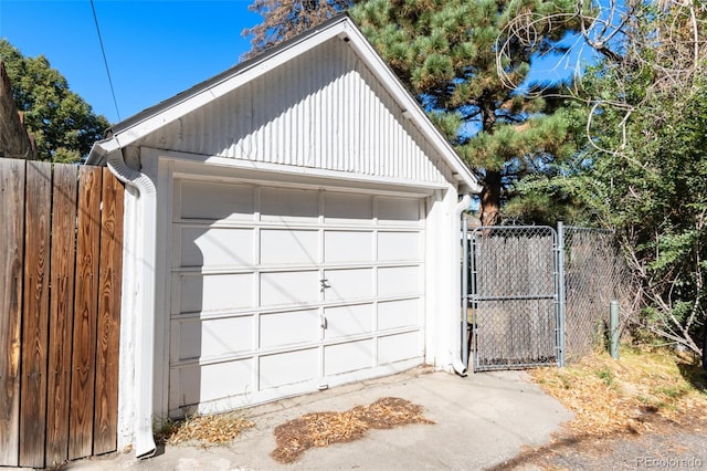 detached garage with a gate and fence