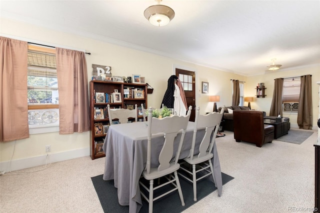 dining space with light carpet, crown molding, and baseboards