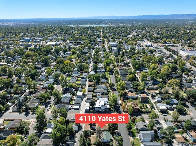 aerial view of property and surrounding area featuring a mountain backdrop and nearby suburban area