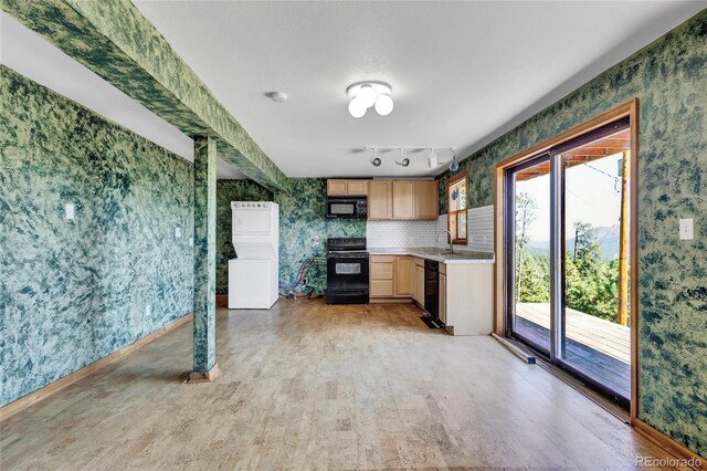 kitchen featuring rail lighting, a wealth of natural light, light wood-type flooring, and black appliances