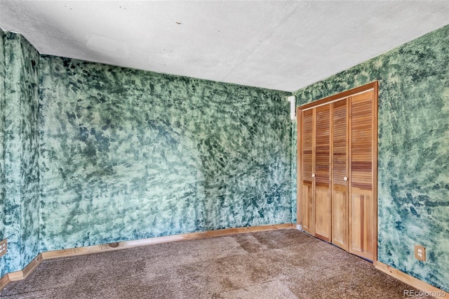 carpeted spare room featuring a textured ceiling