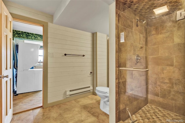 bathroom with a baseboard radiator, toilet, and tiled shower