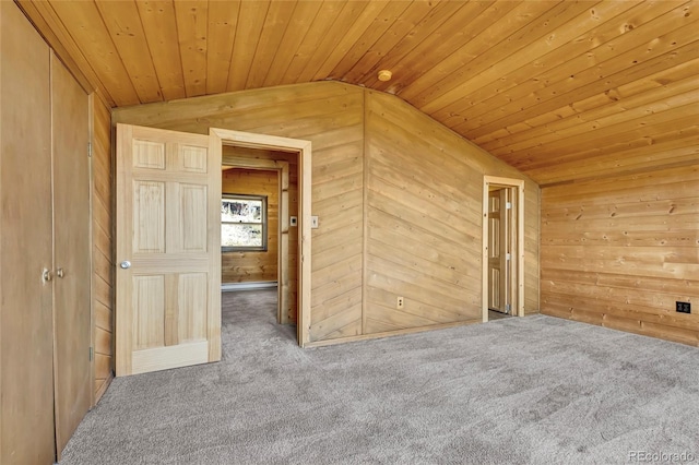 interior space featuring wooden walls, vaulted ceiling, wooden ceiling, and carpet floors