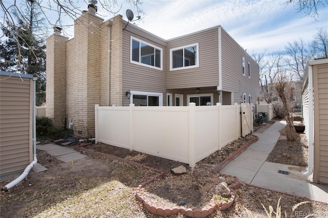 exterior space featuring a chimney and fence