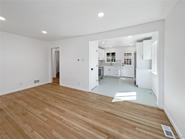 unfurnished living room featuring light hardwood / wood-style floors and sink