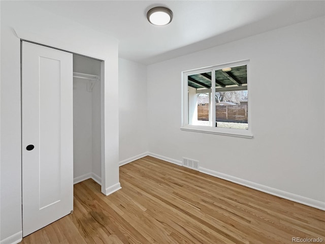 unfurnished bedroom featuring light hardwood / wood-style flooring and a closet