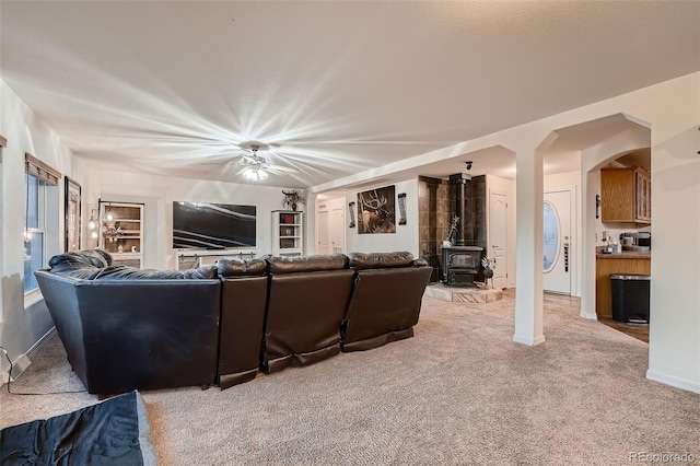 carpeted living room with a wood stove