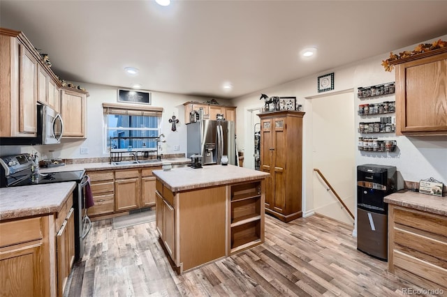 kitchen with sink, light hardwood / wood-style flooring, stainless steel appliances, and a kitchen island