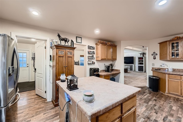 kitchen featuring stainless steel fridge, dark hardwood / wood-style floors, and a kitchen island