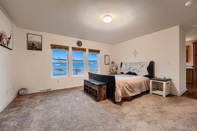 bedroom with light carpet and a textured ceiling