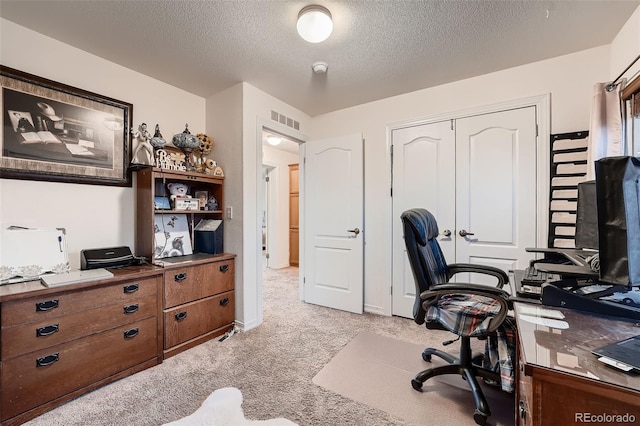 carpeted office space with a textured ceiling