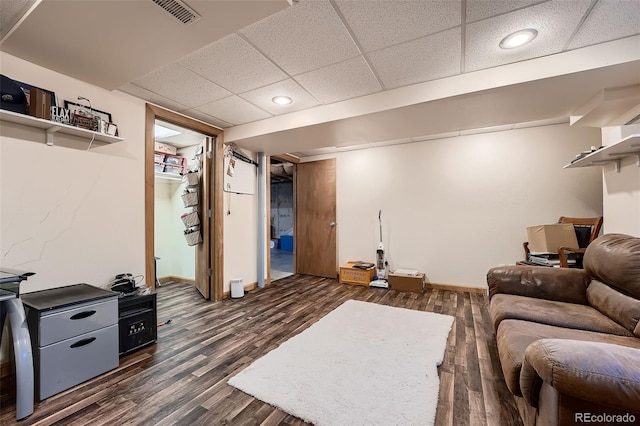 living room with dark hardwood / wood-style floors and a drop ceiling