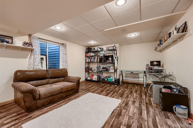 living room with hardwood / wood-style floors and a drop ceiling