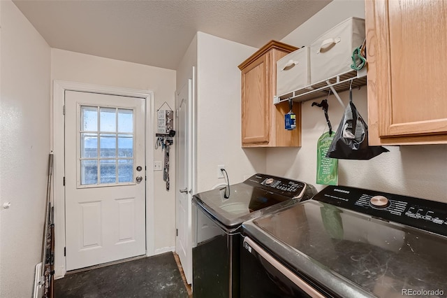 washroom featuring separate washer and dryer, cabinets, and a textured ceiling