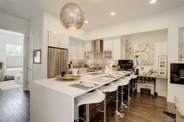 3030 Wilson Ct Unit 5, Denver, CO 80205 - kitchen with high end refrigerator, wall chimney range hood, dark wood-style floors, white cabinets, and recessed lighting