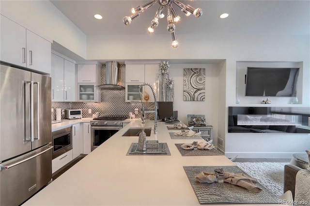 3030 Wilson Ct Unit 5, Denver, CO 80205 - kitchen featuring high end appliances, wall chimney range hood, light countertops, white cabinetry, and recessed lighting
