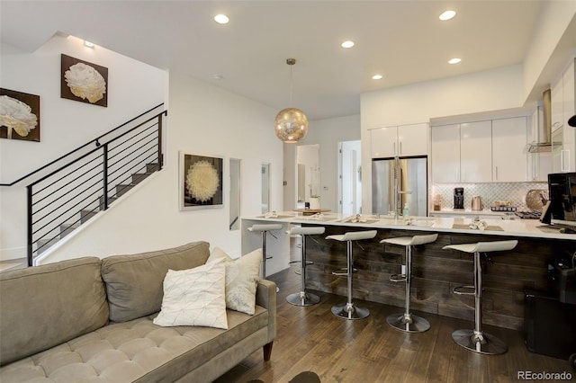 3030 Wilson Ct Unit 5, Denver, CO 80205 - kitchen featuring stainless steel fridge, white cabinetry, light countertops, a kitchen bar, and dark wood-style floors