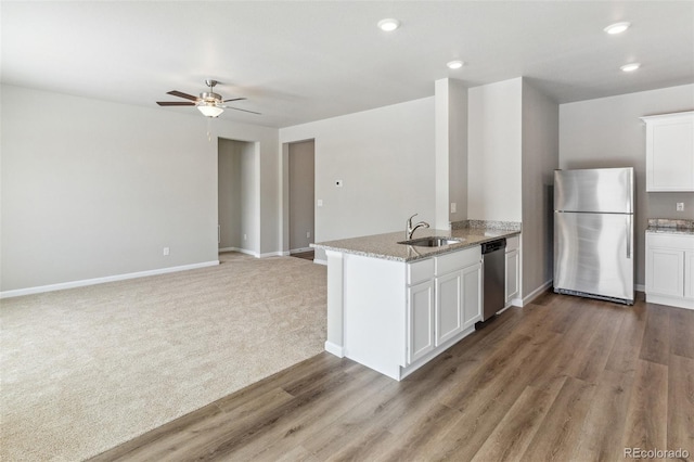 2171 Christina St, Fort Lupton, CO 80621 - kitchen featuring stainless steel appliances, a sink, a peninsula, white cabinetry, and a ceiling fan