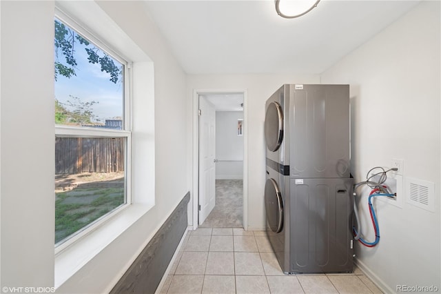 3817 Osage St, Denver, CO 80211 - laundry room with stacked washer and clothes dryer, healthy amount of natural light, and light tile patterned flooring