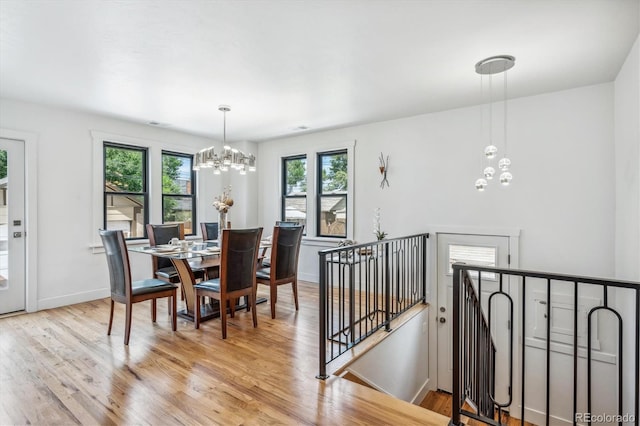 dining room with a chandelier, a healthy amount of sunlight, and light hardwood / wood-style flooring