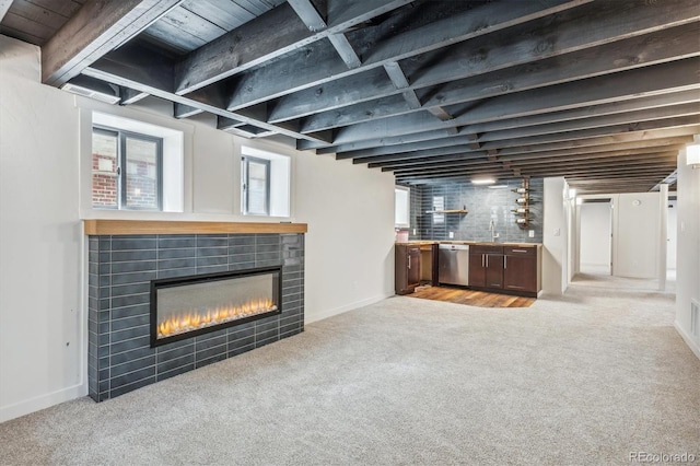 basement with a tile fireplace, light carpet, and wooden ceiling