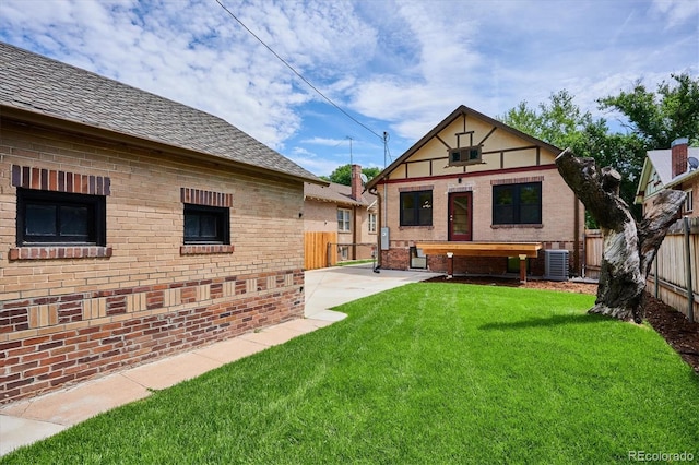 rear view of house with a lawn and cooling unit