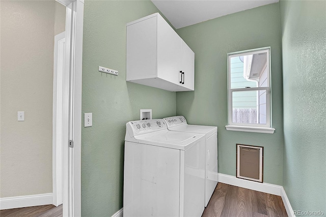 laundry area featuring cabinet space, washing machine and dryer, baseboards, and dark wood-type flooring