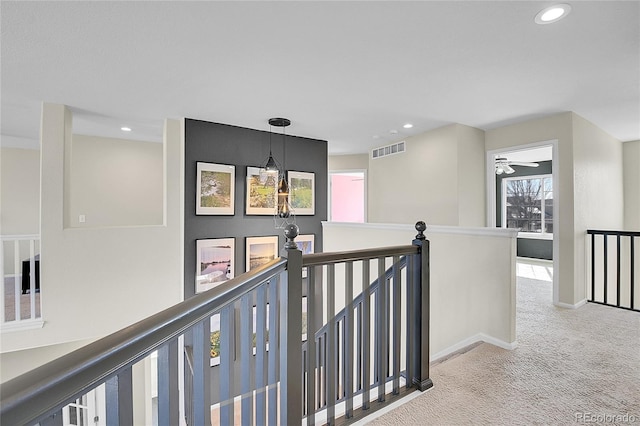 hallway featuring carpet, visible vents, an upstairs landing, and recessed lighting