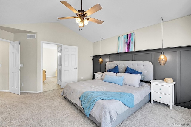 bedroom featuring lofted ceiling, visible vents, ensuite bathroom, a ceiling fan, and carpet flooring