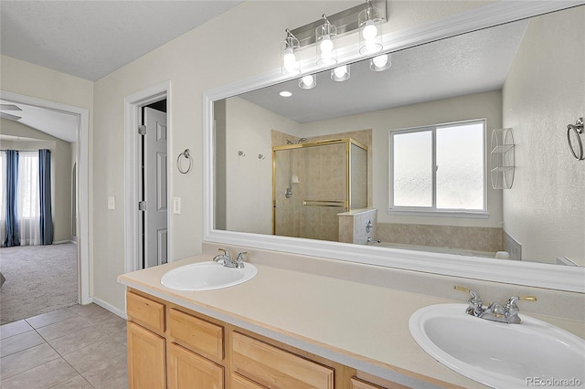 full bathroom with double vanity, tile patterned flooring, a sink, and a shower stall