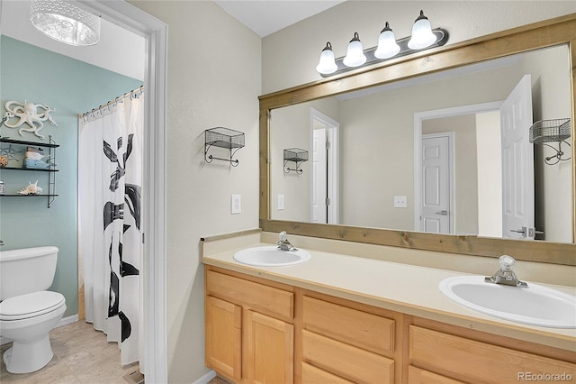 bathroom with toilet, double vanity, and a sink