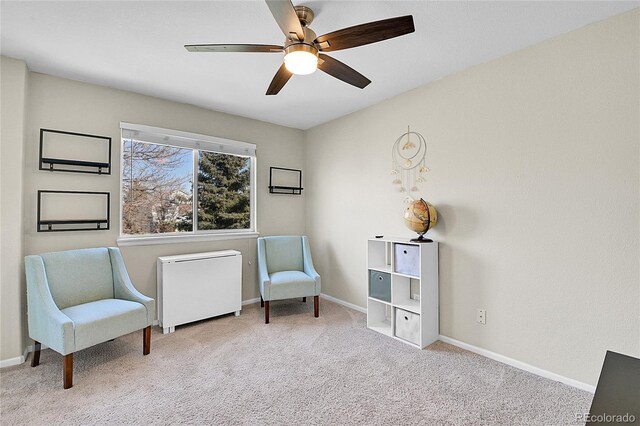 living area featuring a ceiling fan, carpet, radiator, and baseboards