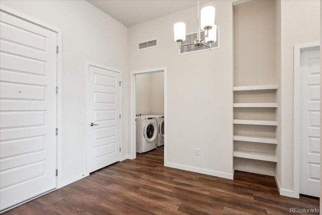 washroom with washing machine and clothes dryer, dark hardwood / wood-style flooring, and a notable chandelier