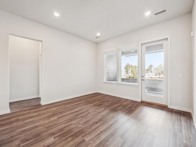 empty room with recessed lighting, visible vents, baseboards, and wood finished floors