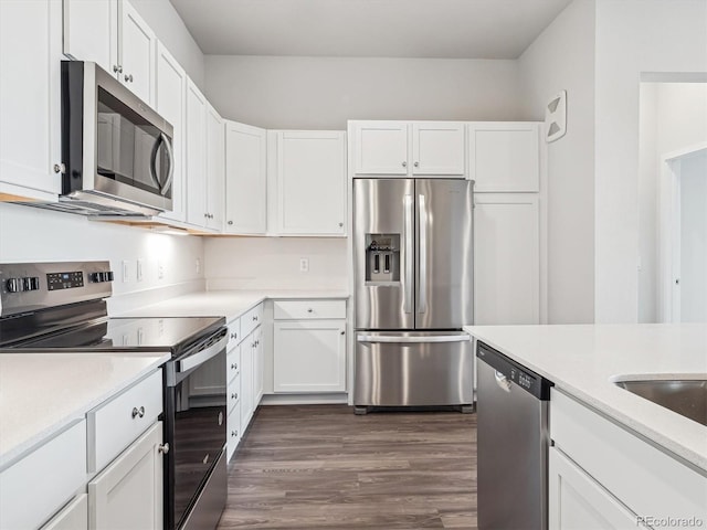 kitchen featuring dark wood-style floors, light countertops, appliances with stainless steel finishes, and white cabinetry