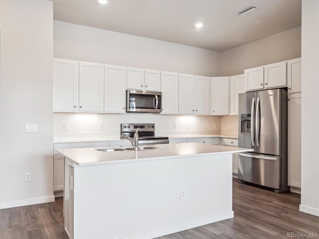 485 Interlocken Blvd Unit 101, Broomfield, CO 80021 - kitchen with appliances with stainless steel finishes, light countertops, a center island with sink, dark wood-type flooring, and white cabinetry