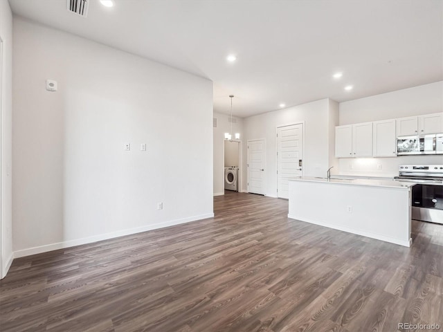 485 Interlocken Blvd Unit 101, Broomfield, CO 80021 - kitchen with stainless steel appliances, washer / dryer, a chandelier, dark wood-type flooring, and recessed lighting