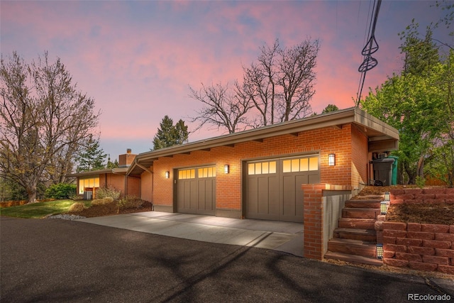 view of front of house with brick siding, aphalt driveway, and a chimney