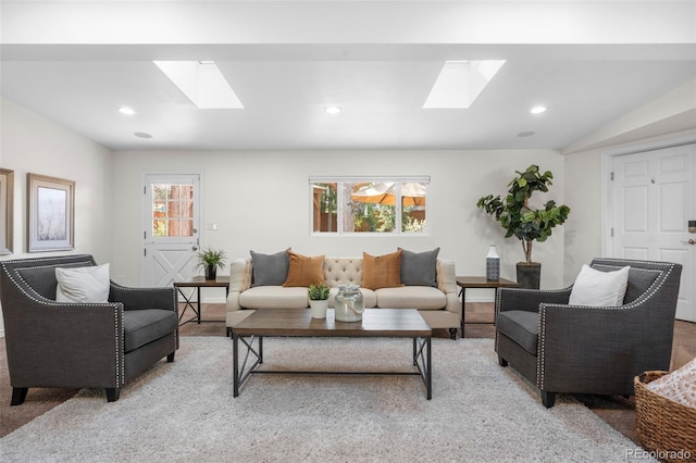 living room featuring a skylight, recessed lighting, and light colored carpet